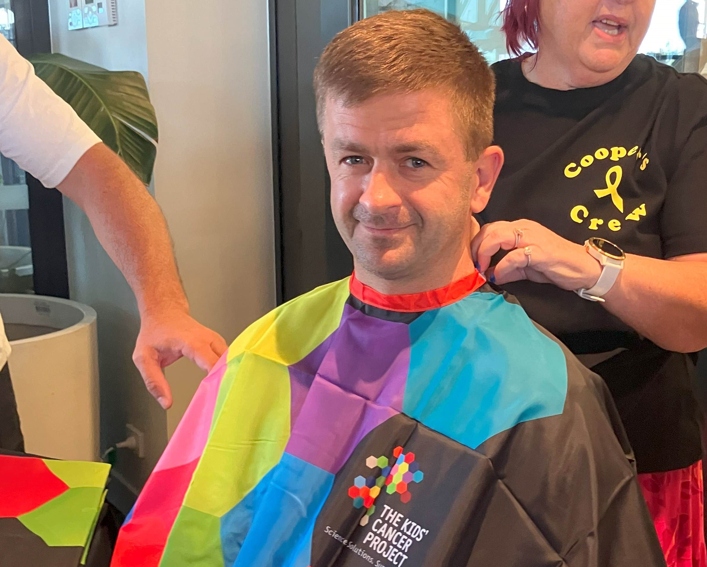 Community team member getting his head shaved for funsraiser