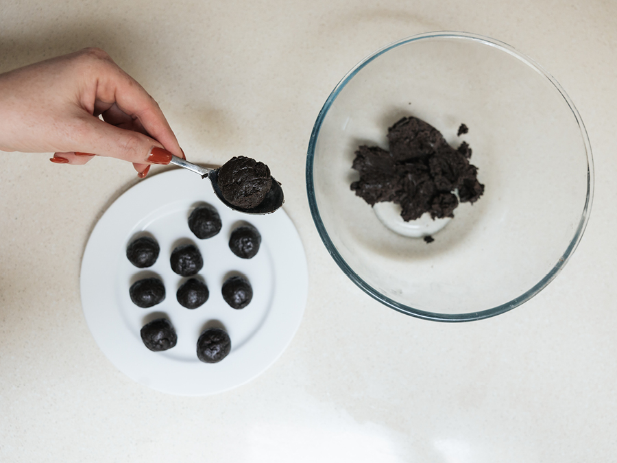 A white plate with rolled balls made from a blend of Oreo cookies and cream cheese.