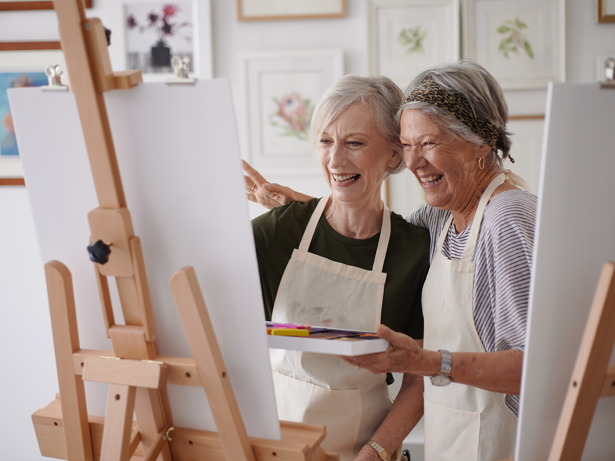 Two friends painting together enjoying the messy arts studio in a Stockland Halcyon community.