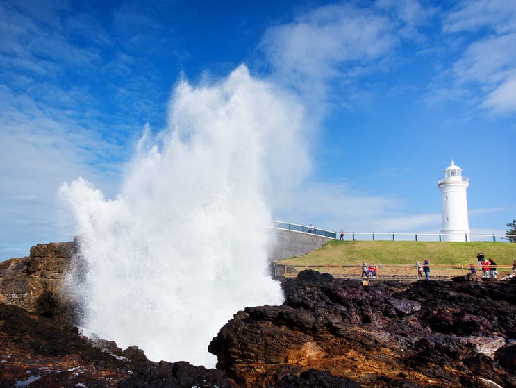 Blowhole with lighthouse in background