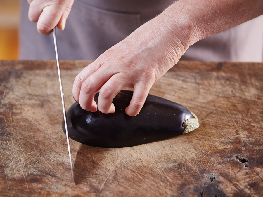 Using the claw technique to chop an eggplant