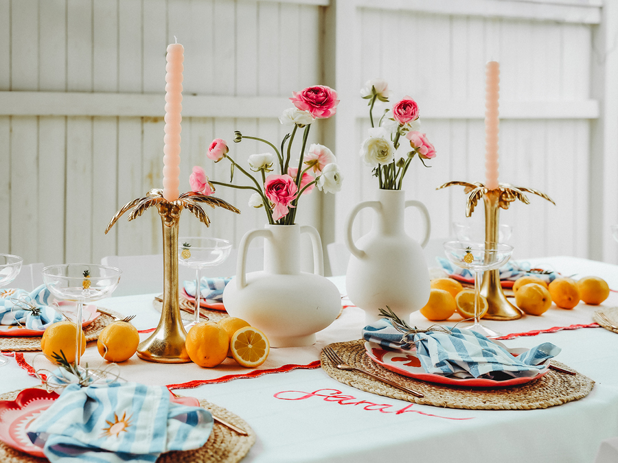 Table styled with candles, flowers and fruit