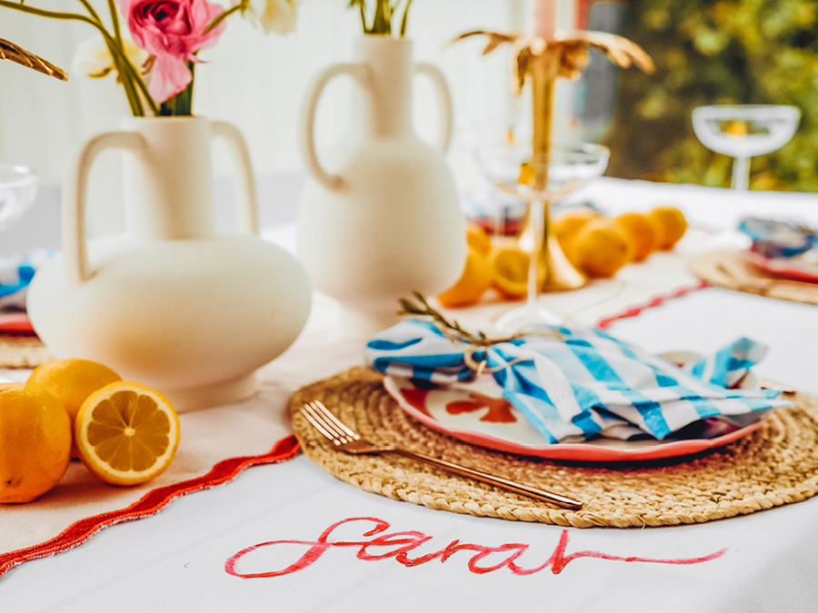 Table styled with vases, glasses, fruit, and dinnerware