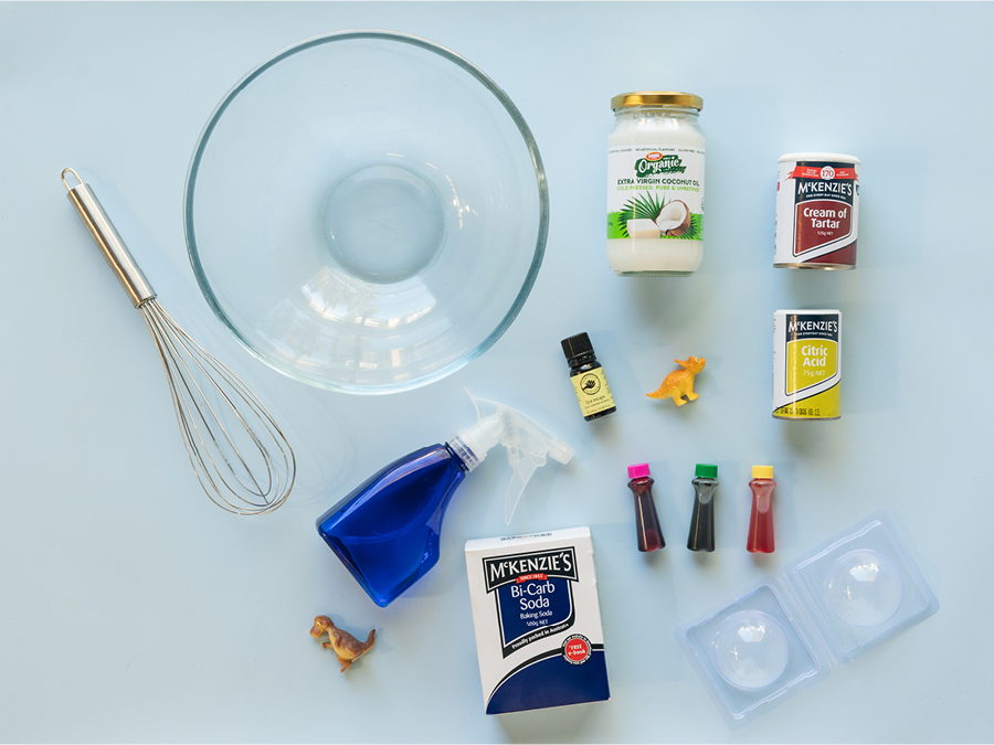 Miscellaneous products to create DIY bath bombs including an ice cube tray, mixing bowl, whisk, bi-carb soda, and citric acid.