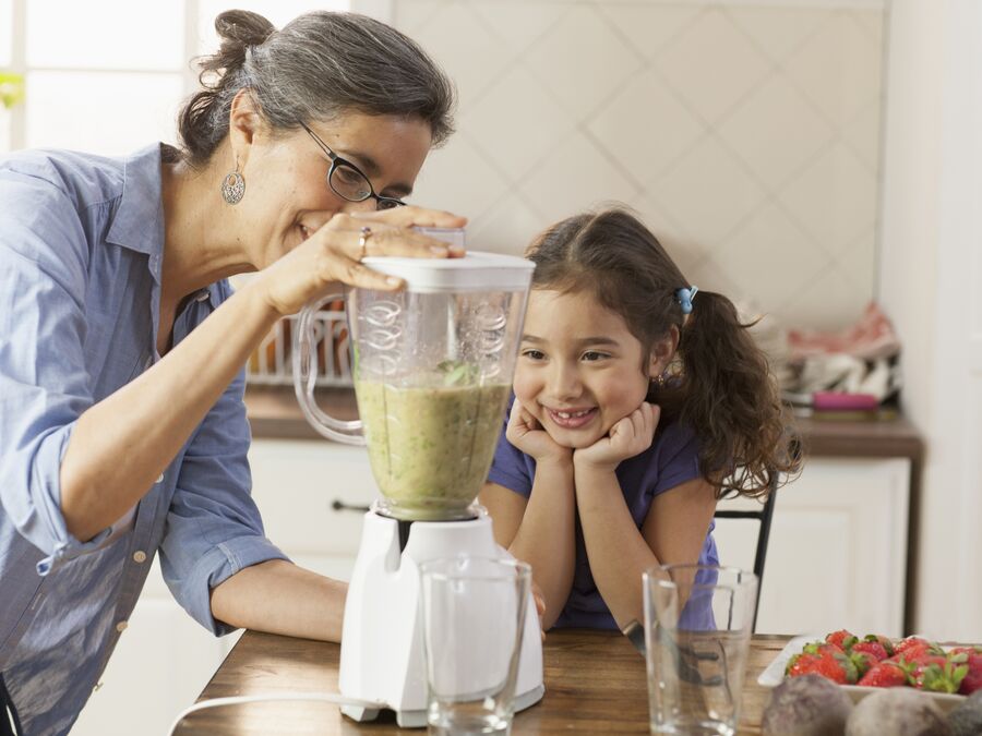 A Woman and young girl using a food blender