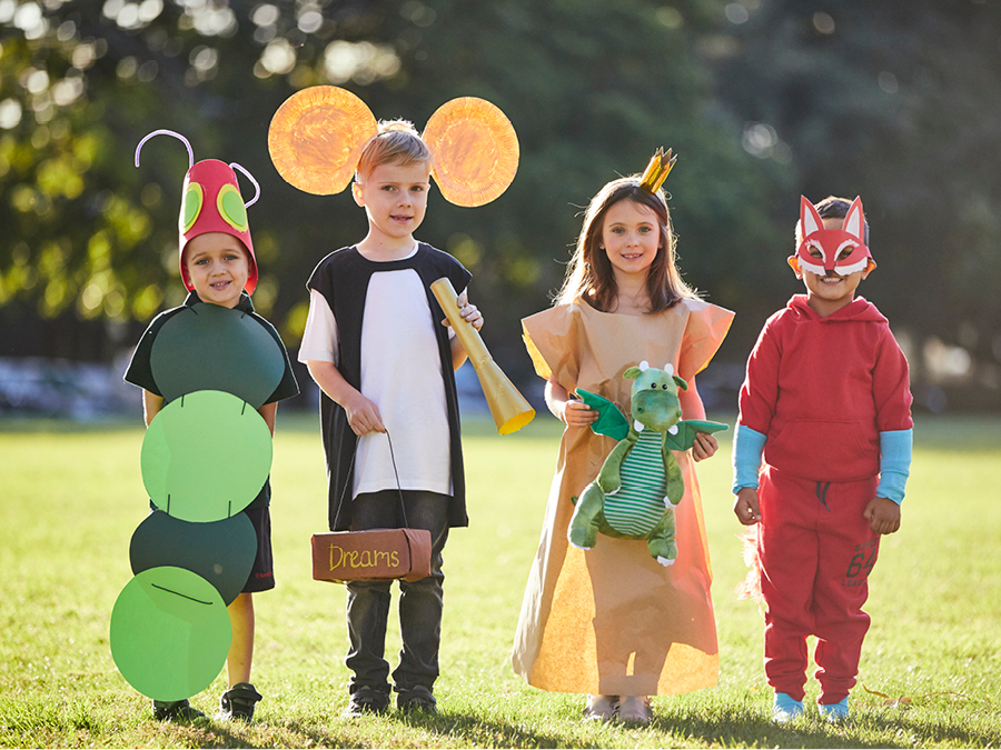 Four kids standing outside in costumes